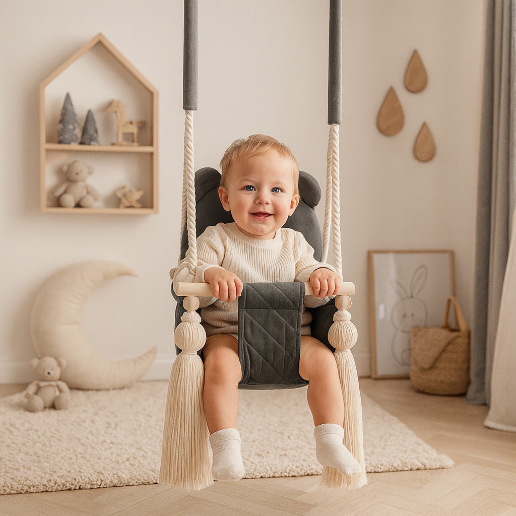 Enfant souriant sur une balançoire bébé en velours gris foncé