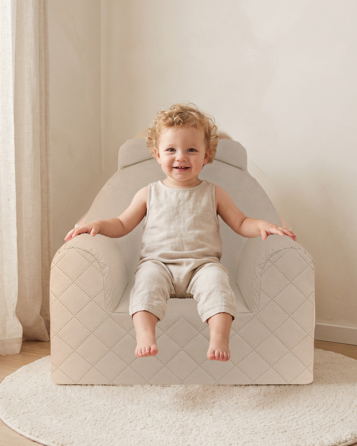 Enfant souriant assis dans un fauteuil bébé ourson en velours beige, dans une chambre d'enfant lumineuse